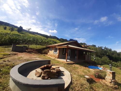 a backyard with a fire pit in front of a house at Cabana do Camelo in São Bento do Sapucaí