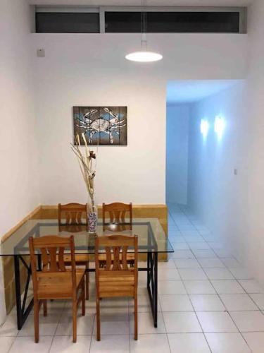 een eetkamer met een glazen tafel en stoelen bij Brand new apartment in the heart of Saint Julians in Tal-Għoqod