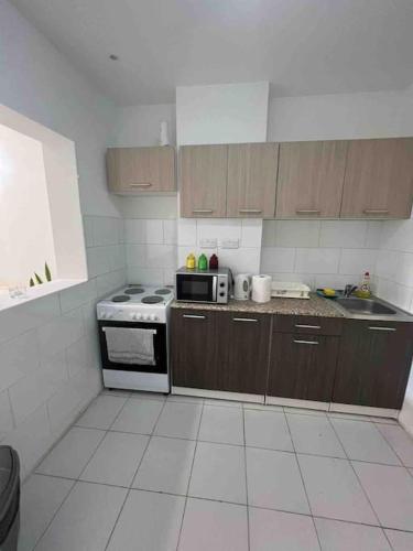 een keuken met een fornuis en een magnetron bij Brand new apartment in the heart of Saint Julians in Tal-Għoqod