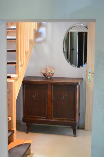 a wooden dresser in a room with a mirror at U Rybaka in Braniewo