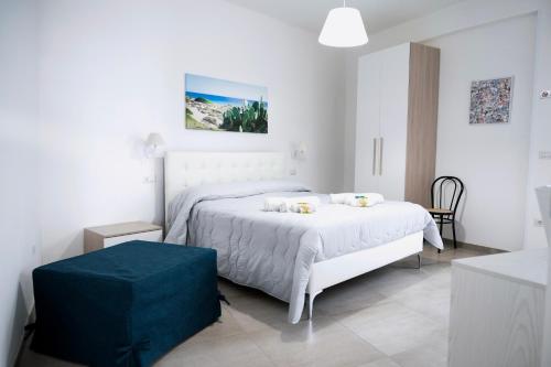 Habitación blanca con cama y reposapiés azul en Bed and Breakfest Terra d'Arneo, en Leverano