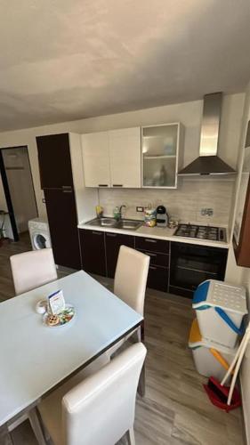 een keuken met een witte tafel en stoelen en een keuken met bij Casetta ruta camogli in Camogli