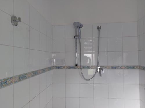 um chuveiro na casa de banho com azulejos brancos em Casa civico22 em Fratta Todina