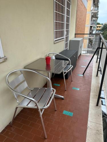 un patio con tavolo e sedie su un balcone di LA LOGGIA a Roma