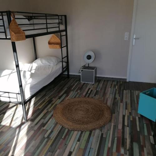 a bedroom with two bunk beds and a rug at Maison de bourg à 5 minutes de Soulac Sur Mer in Talais