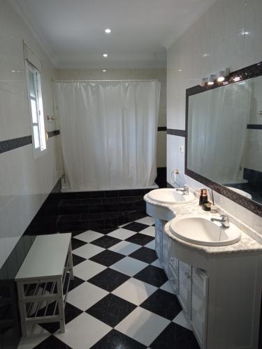 a bathroom with two sinks and a large mirror at Casa Rural El Algarrobo in Utrera