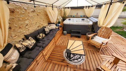 an overhead view of a deck with a couch and a tub at Gîte au cœur des vignes avec piscine et spa in Saudoy