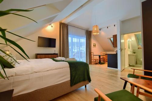 una habitación de hotel con una cama grande y una mesa en Apartamenty Dolina Jawornika en Wisła