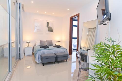 ein Schlafzimmer mit einem Bett und einem Stuhl in einem Zimmer in der Unterkunft Luxury Villa Punta Mujeres in Punta de Mujeres