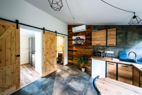 a kitchen with wooden cabinets and a wooden table at Domek Trolla in Sieraków