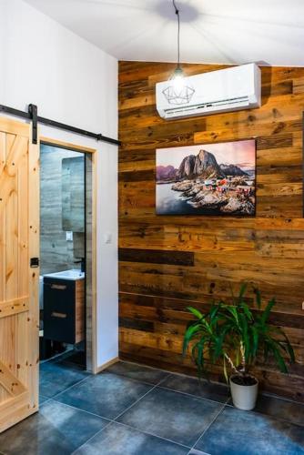a hallway with a wooden wall with a potted plant at Domek Trolla in Sieraków