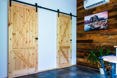 two wooden doors in a room with wooden walls at Domek Trolla in Sieraków