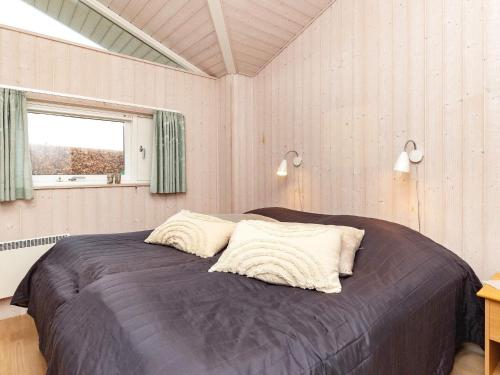 una camera con un letto con due cuscini sopra di Holiday home Karrebæksminde LIII a Karrebæksminde