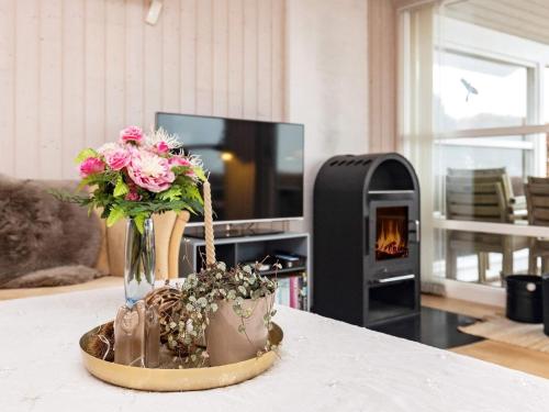 a vase of flowers on a table with a fireplace at 6 person holiday home in Karrebæksminde-By Traum in Karrebæksminde