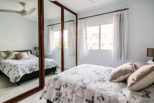 a bedroom with a mirror and a bed at Golf View Apartment - stunning ocean view Golf del Sur in San Miguel de Abona