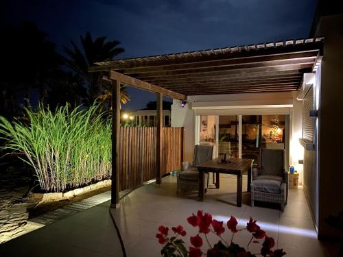 a backyard patio with a wooden pergola at night at Vila Mare - Praia de Chaves frontline in Cabeçadas