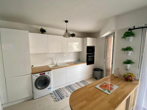 une cuisine avec des armoires blanches et une machine à laver dans l'établissement Nice Port , 2BR, 6 Guests, Walk to Beach and Old Town, à Nice