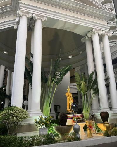 a large building with white columns and plants in it at Sky Beach Beachfront Pattaya in Pattaya North