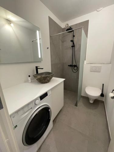 uma casa de banho com uma máquina de lavar roupa e um WC em RE-Seapark em Hvidovre