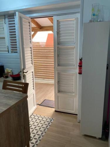 a kitchen with two open doors and a kitchen floor at Agréable logement, bien situé in Schœlcher