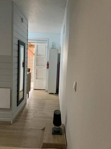 un corridoio con uno sgabello nero al centro di una stanza di Agréable logement, bien situé a Schœlcher