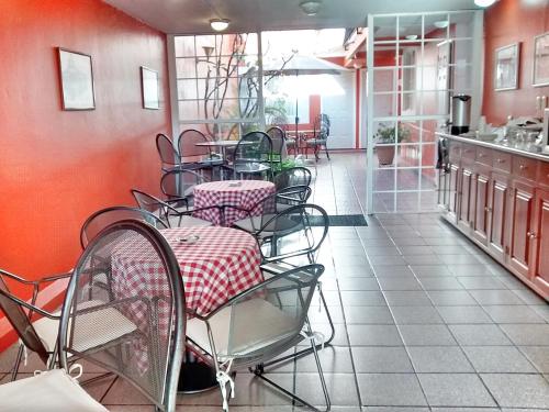 a restaurant with tables and chairs in a room at Hotel Camba in Oaxaca City