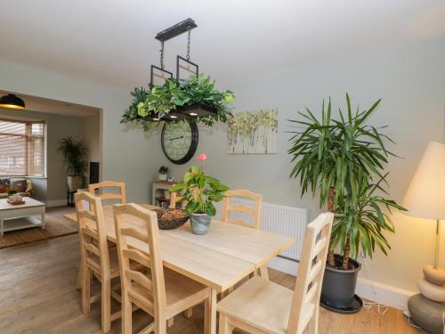 a dining room with a table and chairs and plants at Birch House in Corsham
