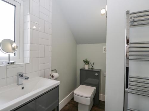 科斯漢姆的住宿－Birch House，白色的浴室设有卫生间和水槽。