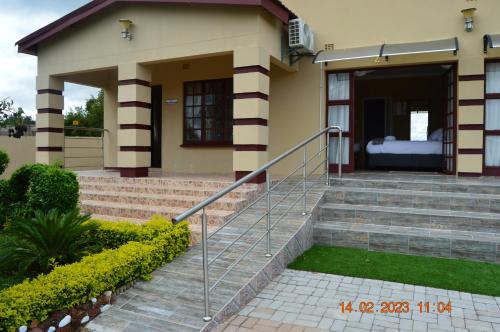 a house with a staircase leading to the front door at Glorious Home Bed & Breakfast in Mochudi