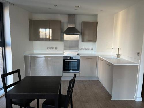 a kitchen with a table and a black table and chairs at Brand new heart of Birmingham one bedroom in Birmingham