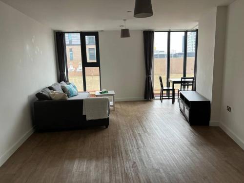 a living room with a couch and a table at Brand new heart of Birmingham one bedroom in Birmingham