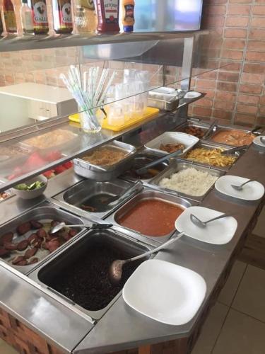 a buffet line with many different food items at Golden Lake - 1 quarto in Arraial do Cabo