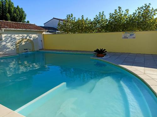 une piscine avec de l'eau bleue dans une cour arrière dans l'établissement Le Gîte de Marilou classé 3 étoiles Vallon Pont d'Arc, résidence privée piscine, à Vallon-Pont-dʼArc