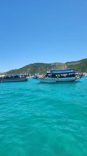 three boats floating on the water in the ocean at Golden Lake - 1 quarto in Arraial do Cabo