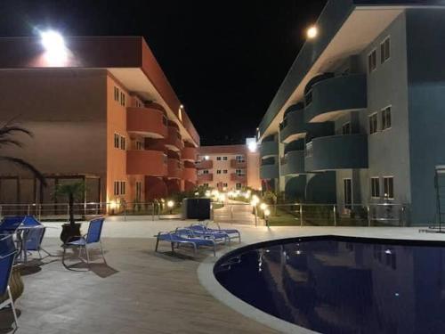 a swimming pool in front of a building at night at Golden Lake - 1 quarto in Arraial do Cabo
