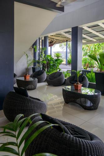 a lobby with black wicker chairs and plants at Gazelle International Hotel in Kokopo