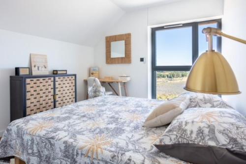 1 dormitorio con 1 cama con lámpara y ventana en BURON FRANCk, en Aubrac