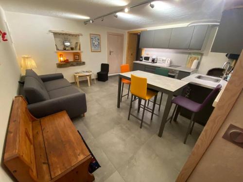 un salon et une cuisine avec un canapé et une table dans l'établissement Dans hameau, près des pistes logement de plein pied au calme, à Taninges