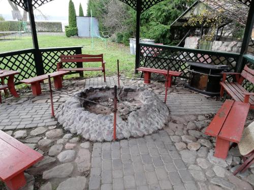 a fire pit with two picnic tables and benches at Pod Sową in Drawsko Pomorskie