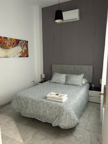 a bedroom with a bed and a painting on the wall at The Spot Central Hostel in Seville