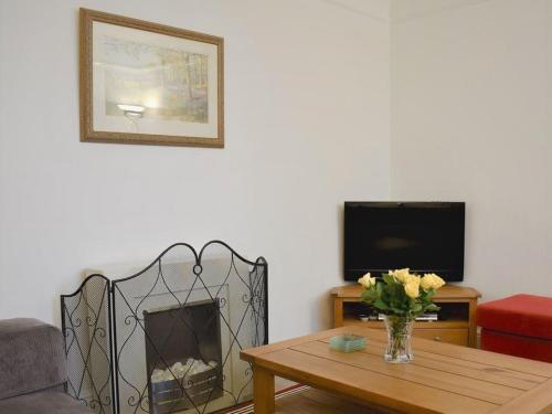a living room with a table and a fireplace at Beech Tree Cottage with free parking in Bury Saint Edmunds