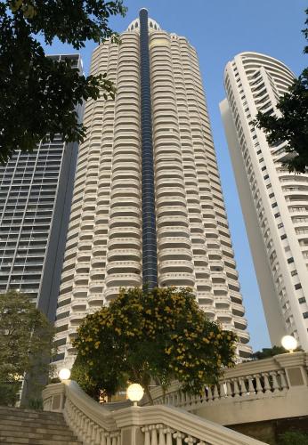 two tall buildings with a tree in front of them at Sky Beach Beachfront Pattaya in Pattaya North