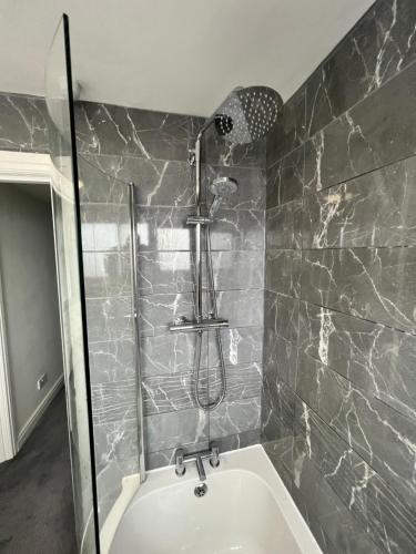 a bathroom with a shower and a bath tub at Very comfy 3 bed town house in Ashton under Lyne