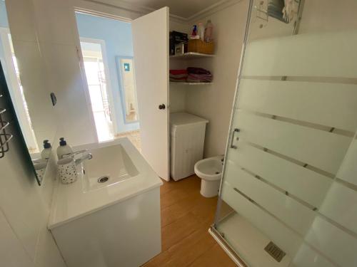 a white bathroom with a sink and a toilet at Relax and sun in Santa Pola