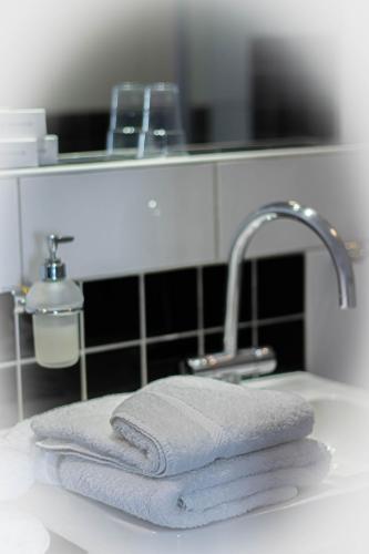 a pile of towels sitting on a bathroom sink at Hotel de Boegschroef in Delfzijl