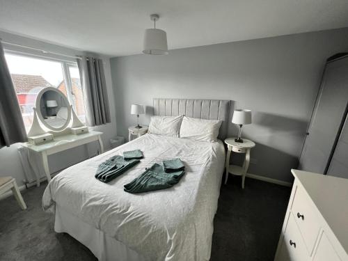 1 dormitorio con 1 cama con 2 albornoces. en Very comfy 3 bed town house, en Ashton-under-Lyne