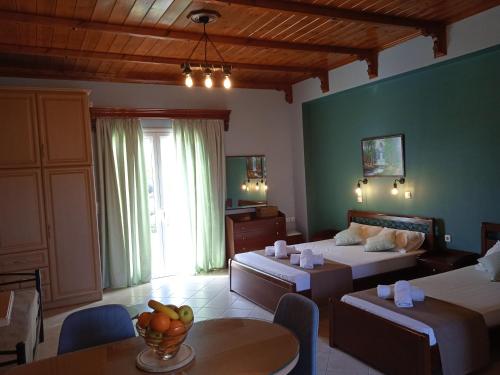 a bedroom with two beds and a table with a bowl of fruit at Katerina house in Finikounta