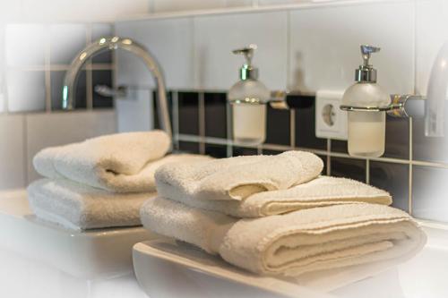 a pile of towels sitting on a sink in a bathroom at Hotel de Boegschroef in Delfzijl