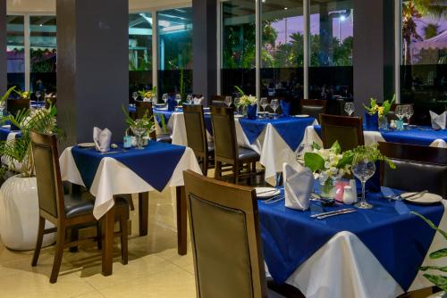 a dining room with blue tables and chairs at Gazelle International Hotel in Kokopo