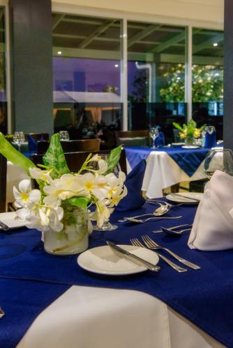 a table with white flowers in a vase on a blue table cloth at Gazelle International Hotel in Kokopo